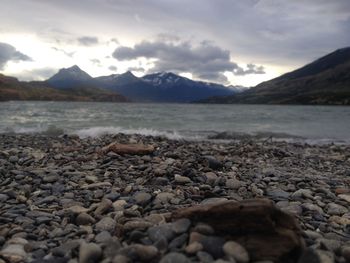 Surface level of pebble beach against sky