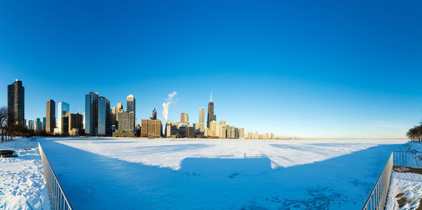 View of buildings against clear blue sky