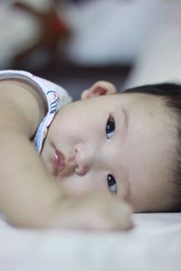 Portrait of cute baby lying on bed