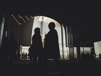 Rear view of silhouette people walking in corridor