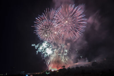 Low angle view of firework display at night
