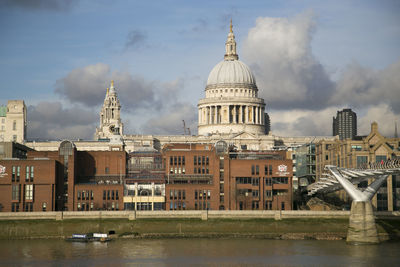 Buildings in city against cloudy sky