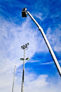 Low angle view of electricity pylon against cloudy sky