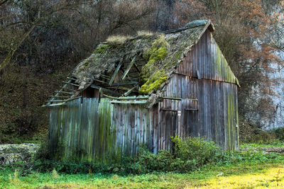 Abandoned house by barn