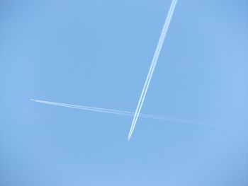 Low angle view of vapor trail against blue sky