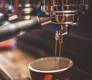 Close-up of cup below coffee maker