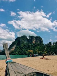 Cropped image of longtail boat at beach against sky