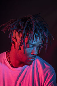 Close-up portrait of mid adult man against black background