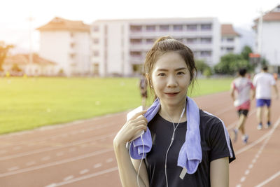 Portrait of beautiful young athlete standing on running track