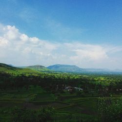 Scenic view of grassy field against cloudy sky