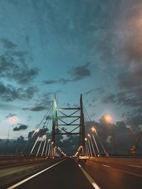 Bridge over road against sky at dusk