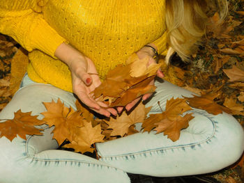 High angle view of woman lying on yellow leaves