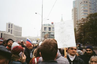 People on street against buildings in city