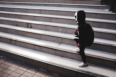 Side view of woman standing on staircase