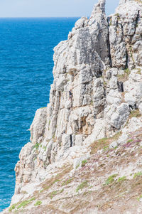 Rock formations by sea against sky