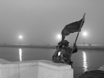 Sculpture by sea against clear sky