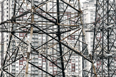 Electricity pylons against buildings in city