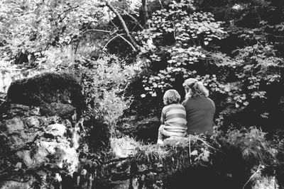 Rear view of mother with trees against plants