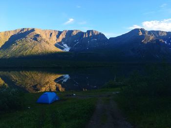 Scenic view of lake by mountain against sky