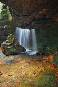 Waterfall falling from rock formation in forest