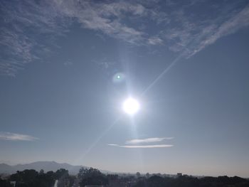 Low angle view of bright sun in sky