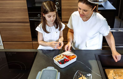 Woman standing on cutting board at home