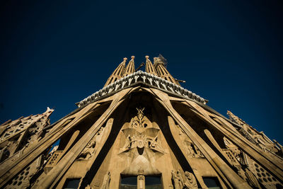 Low angle view of statue of building against blue sky