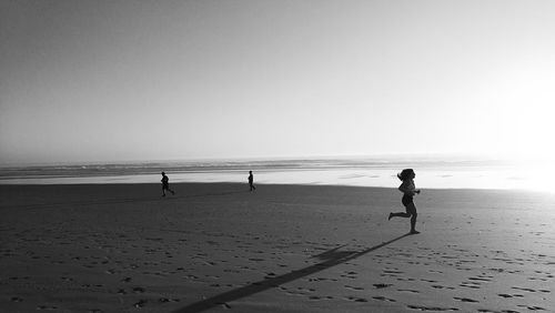 Boy on beach against clear sky