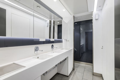 Public or office interior of male restroom with sinks and big mirror. modern design bathroom 