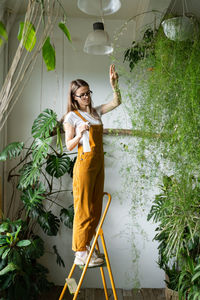 Young woman by potted plants