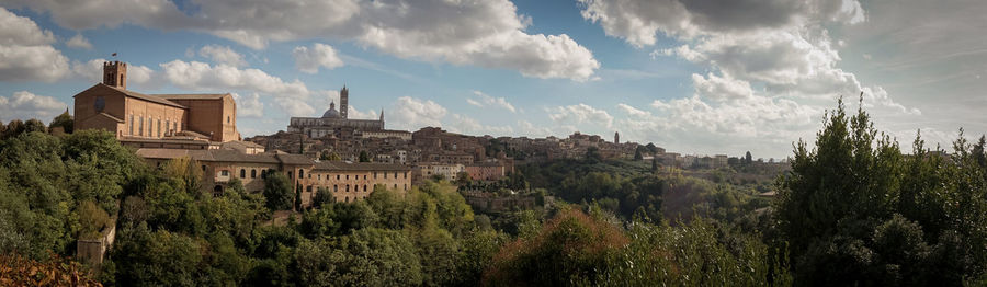 Panoramic view of trees and buildings against sky