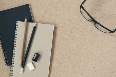 High angle view of office supplies with eyeglasses on table