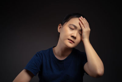 Portrait of teenage girl against black background