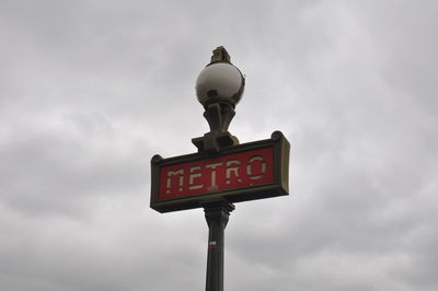 Low angle view of information sign against sky