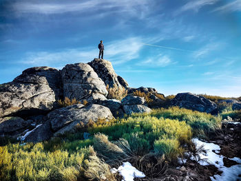 Man standing on cliff against sky