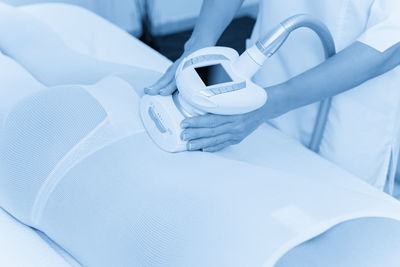 Midsection of doctor examining patient in hospital