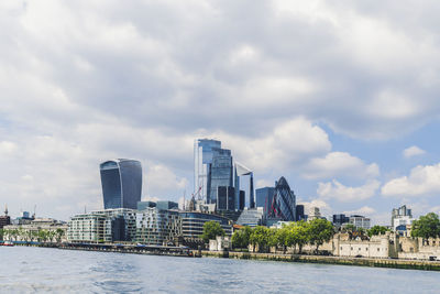 River by buildings against sky in city