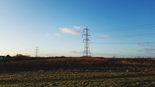 Electricity pylons against sky