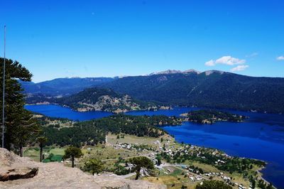 Scenic view of lake and mountains against blue sky