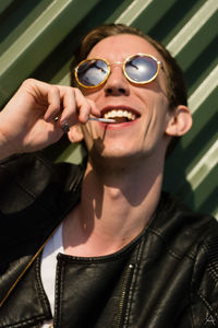 Close-up of smiling man eating lollipop