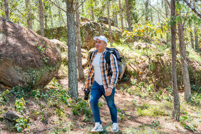 Full length of woman standing in forest