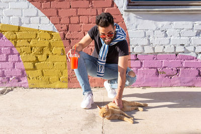 Full length of young man standing against wall