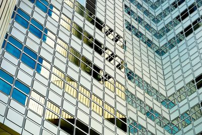 Low angle view of glass building against sky