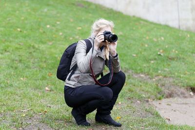 Man photographing with camera on field