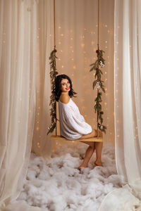 Portrait of young woman sitting on snow