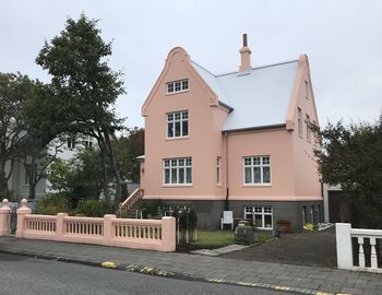 Residential building by street against sky