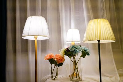 Illuminated lamps with flower vases at home