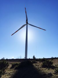 Low angle view of wind turbine on landscape against sky