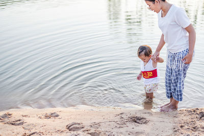 Mother and daughter play on the beach.