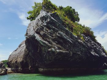 Low angle view of rock formation in sea against sky